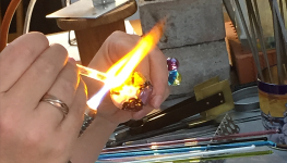 Heating the glass with the lamp to create exciting new glass jewellery pieces.